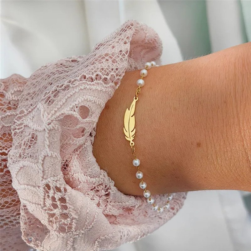Roestvrijstalen armband met witte parels en veer Roestvrijstalen armband met witte parels en veer